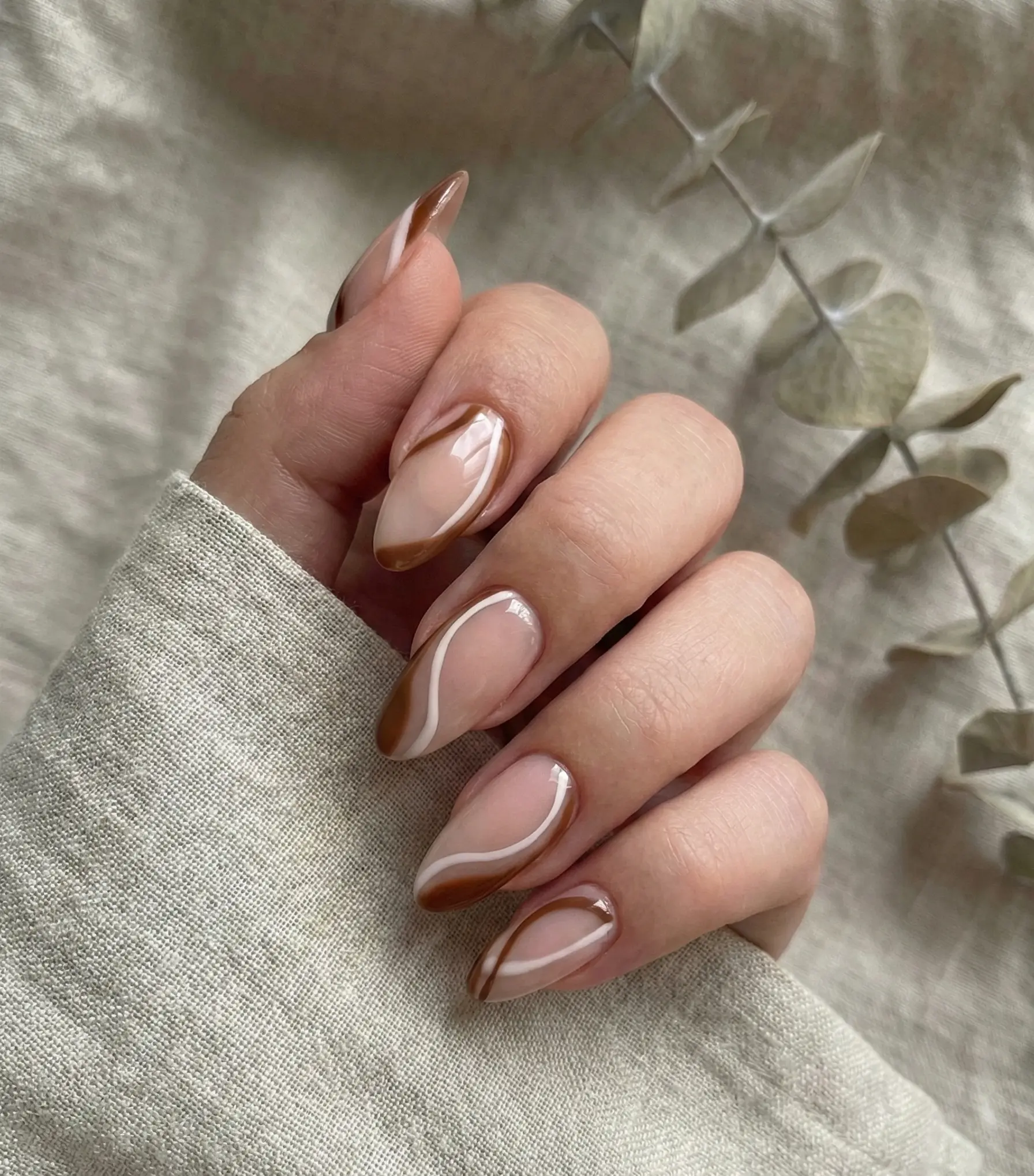 Trendy Brown And White Abstract Swirls On Almond Nails For A Minimalist Latte Look